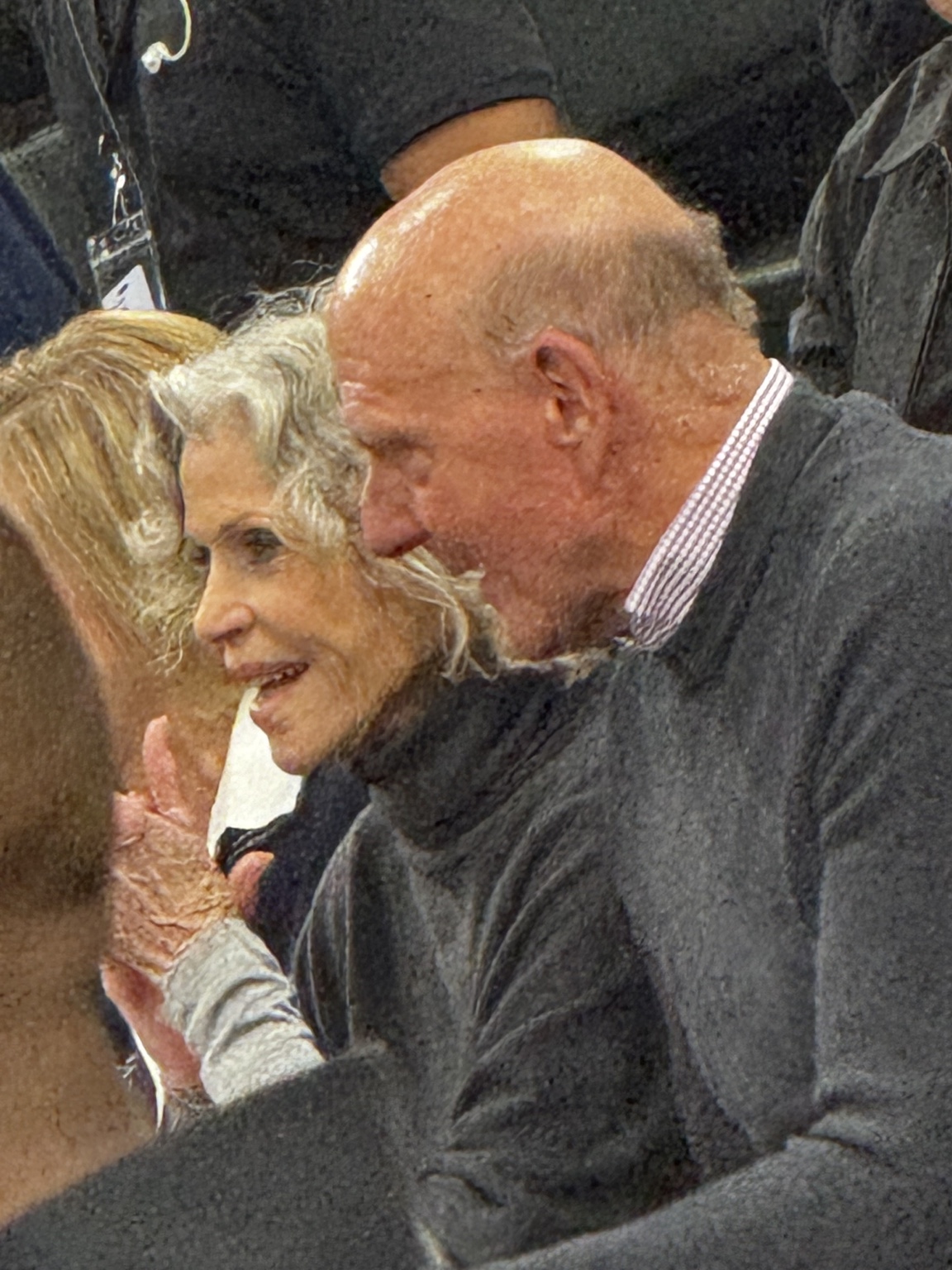 Spectators in a candid courtside conversation